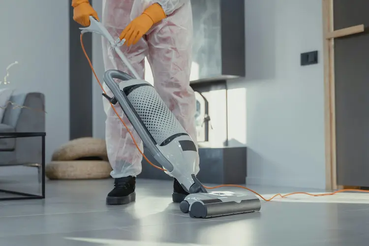Post-construction cleaning professional using HEPA vacuum in new Raleigh NC home